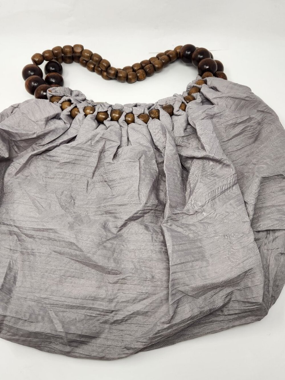 New gray sling cloth bag with dark brown and light brown bead handle.